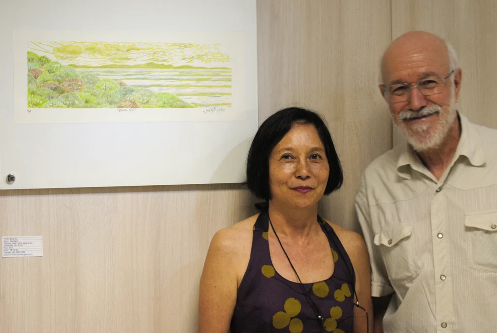 Foto de Julia Iguti com Antônio C. Silva ao lado de gravura