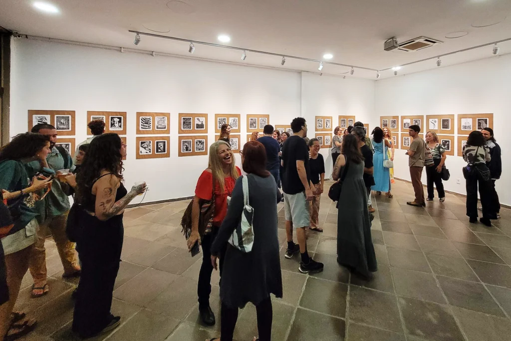 Panorama da exposição com todas as obras e visitantes distribuídos em pequenos grupos
